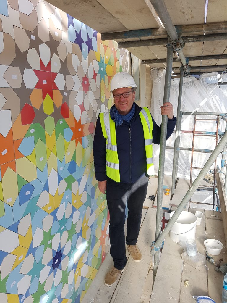 Eric Broug in front of large Islamic geometric composition in Dewsbury